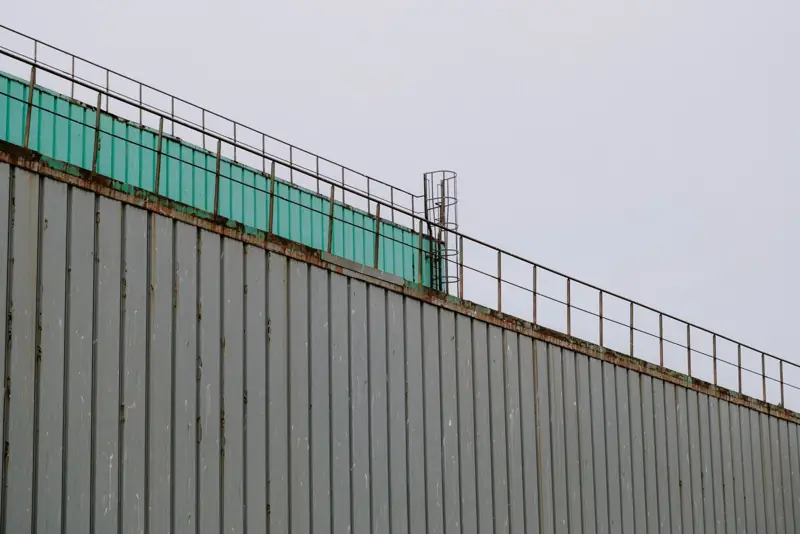Corrugated metal wall and roof edge with a railing